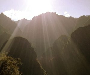 Sunlight streaming over mountains showcases the healing power of the sun and its beneficial effects on health.